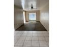 Bright living room featuring tile and carpet flooring, a ceiling fan, and large window at 1108 E Villa Rita Dr, Phoenix, AZ 85022