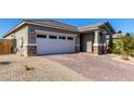 House exterior showcasing a brick driveway and two-car garage at 11980 S 173Rd Ave, Goodyear, AZ 85338