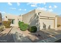 Tan stucco house with a two-car garage and manicured landscaping at 14444 W Moccasin Trl, Surprise, AZ 85374