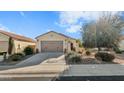 Front view of a single-story home with a two-car garage and desert landscaping at 26119 W Oraibi Dr, Buckeye, AZ 85396