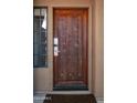 Ornate wooden front door with a keyless entry system at 9212 E Whitethorn Cir, Scottsdale, AZ 85266