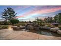 Serene water feature with stacked stone and lush landscaping at 9733 E Lompoc Ave, Mesa, AZ 85209