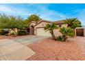 Attractive single-story home with palm trees, desert landscaping, and attached two-car garage at 15912 W Marconi Ave, Surprise, AZ 85374