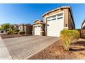 Houses with a three-car garage and brick driveway at 17826 W Straight Arrow Ln, Surprise, AZ 85387