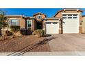 Tan two-story house with a three-car garage and landscaping at 17826 W Straight Arrow Ln, Surprise, AZ 85387