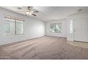 Bright living room with neutral carpeting and ceiling fan at 931 W Cedar Tree Dr, San Tan Valley, AZ 85143