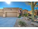 Tan stucco house with a two car garage and desert landscaping at 7143 E Canyon Wren Dr, Gold Canyon, AZ 85118