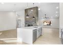 Open concept kitchen with island, white cabinets, and quartz countertops at 7817 W Wethersfield Rd, Peoria, AZ 85381