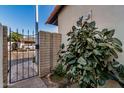 Wrought iron gate entrance with brick accents and lush green foliage at 939 W Mission Ln, Phoenix, AZ 85021