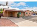 Tan single story house with carport, basketball court, and rock landscaping at 2325 W Orchid Ln, Phoenix, AZ 85021