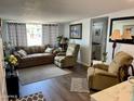 Living room with brown couch, recliner chairs, and large window at 7750 E Broadway Rd # 911, Mesa, AZ 85208