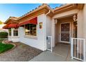 Front entrance with red awnings, decorative sunflower, and white gate at 14105 W Sky Hawk Dr, Sun City West, AZ 85375