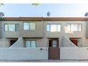 Front view of a two-story stucco townhome with a brown gate at 2040 S Longmore -- # 68, Mesa, AZ 85202