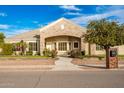 Front view of a single-story house with stone accents, a landscaped yard, and an arched entryway at 21406 E Mewes N Rd, Queen Creek, AZ 85142