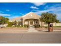 Front view of a single-story house with stone accents, a landscaped yard, and an arched entryway at 21406 E Mewes N Rd, Queen Creek, AZ 85142