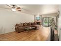 Bright living room with fireplace, sliding glass doors to patio, and laminate flooring at 8651 E Royal Palm Rd # 105, Scottsdale, AZ 85258