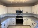 Modern kitchen featuring white cabinets, gray countertops, and stainless steel appliances at 22262 W Tonto St, Buckeye, AZ 85326