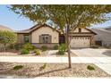 Tan house with brown accents, two-car garage, and landscaped front yard at 2595 S Jeffry St, Gilbert, AZ 85295