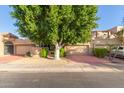 Front view of two-story home with double garage and large tree at 7955 E Chaparral Rd # 11, Scottsdale, AZ 85250