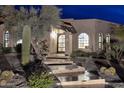 Night view of the home's entryway, showcasing a pathway and desert landscaping at 9446 E Romping Rd, Carefree, AZ 85377