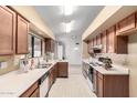 Galley-style kitchen featuring wood cabinets, white countertops, and essential appliances at 17218 N Desert Glen Dr, Sun City West, AZ 85375