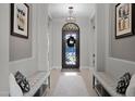 Elegant entryway with an ornate iron front door, twin benches, and decorative art at 30807 N 117Th Dr, Peoria, AZ 85383