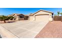 Tan house with a two-car garage and a spacious driveway at 384 W Chuckwagon Ln, San Tan Valley, AZ 85143