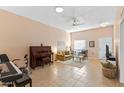 Living room with tile flooring, a piano, and comfortable seating at 13027 N 99Th Dr, Sun City, AZ 85351