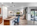 Open kitchen and living room with granite countertops, pendant lights, and stainless steel appliances at 17539 W Silver Fox Way, Goodyear, AZ 85338