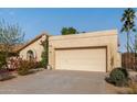 Tan stucco house with a two-car garage and well-maintained landscaping at 2418 W Alamo Dr, Chandler, AZ 85224