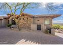 Stone and stucco exterior with tile roof, landscaping, and paver driveway at 11328 E Dreyfus Ave, Scottsdale, AZ 85259