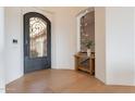 Entryway with a decorative iron door, wood floors, and a console table at 11328 E Dreyfus Ave, Scottsdale, AZ 85259