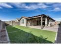 Artificial turf backyard with covered patio and pergola at 15085 W Garfield St, Goodyear, AZ 85338