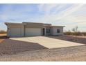 Exterior view of a single-story home with a two-car garage and driveway at 28205 N 213Th Dr, Wittmann, AZ 85361