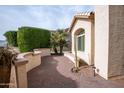 Brick patio with desert landscaping and a curved stucco wall at 16068 W Edgemont Ave, Goodyear, AZ 85395