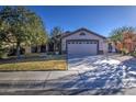 Inviting single-story home with a two-car garage, landscaping, and a welcoming front yard at 3335 E San Angelo Ave, Gilbert, AZ 85234
