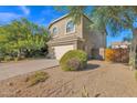 Side view of a two-story home with a gated side yard, landscaping, and attached garage at 4208 E Tether Trl, Phoenix, AZ 85050