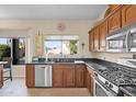 Kitchen with dark granite countertops, wood cabinetry, and stainless steel appliances at 4208 E Tether Trl, Phoenix, AZ 85050