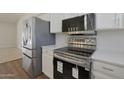 Stainless steel appliances in a modern kitchen with white cabinets at 501 E Desert Hills Estate Dr, Phoenix, AZ 85086