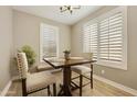 Cozy breakfast nook with a charming table, chairs, and large window with shutters at 10731 E Texas Ave, Mesa, AZ 85212