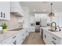 White kitchen with an island, stainless steel appliances, and sleek black hardware at 1805 W Caramel Ct, Queen Creek, AZ 85144