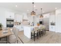 Bright white kitchen featuring an island with seating, stainless steel appliances, and ample counter space at 1805 W Caramel Ct, Queen Creek, AZ 85144