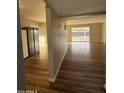 View of the living room and kitchen with wood-look flooring and sliding glass doors at 2207 W State Ave, Phoenix, AZ 85021