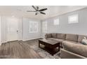 Living room with L-shaped sofa, wood-look floors, and entryway view at 36909 N Coronado Ln, San Tan Valley, AZ 85140