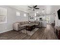 Open living space with L-shaped sofa, wood-look floors, and kitchen views at 36909 N Coronado Ln, San Tan Valley, AZ 85140