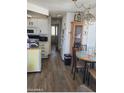 Kitchen and dining area with white cabinetry, wood-look flooring, and a dining table at 4220 E Main St # A52, Mesa, AZ 85205