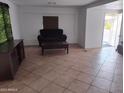 Living room with tile floors, a dark brown sofa, a coffee table, and an entertainment center at 530 S Alma School Rd # 10, Mesa, AZ 85210