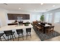 Modern kitchen with island, dark wood cabinets, stainless steel appliances, and dining area at 12639 W Parkway Ln, Avondale, AZ 85323