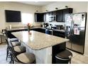 Modern kitchen featuring dark cabinets, stainless steel appliances, and a large island at 8506 S 256Th Dr, Buckeye, AZ 85326