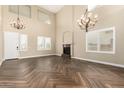 Spacious living room with high ceilings, wood-look tile floors, and a fireplace at 15835 W Desert Mirage Dr, Surprise, AZ 85379
